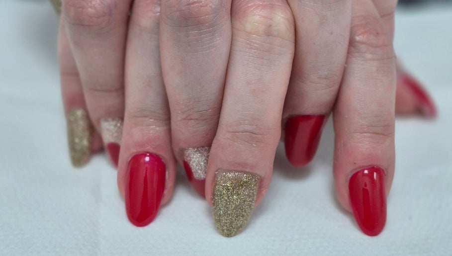 Elegant red and gold glitter nails at Ju'sbeauty, Newcastle upon Tyne, England, GB.