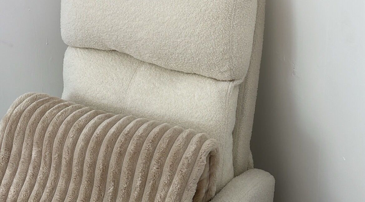 Plush beige recliner with soft throw at BeautyGaze, Stansted Mountfitchet, England, GB.
