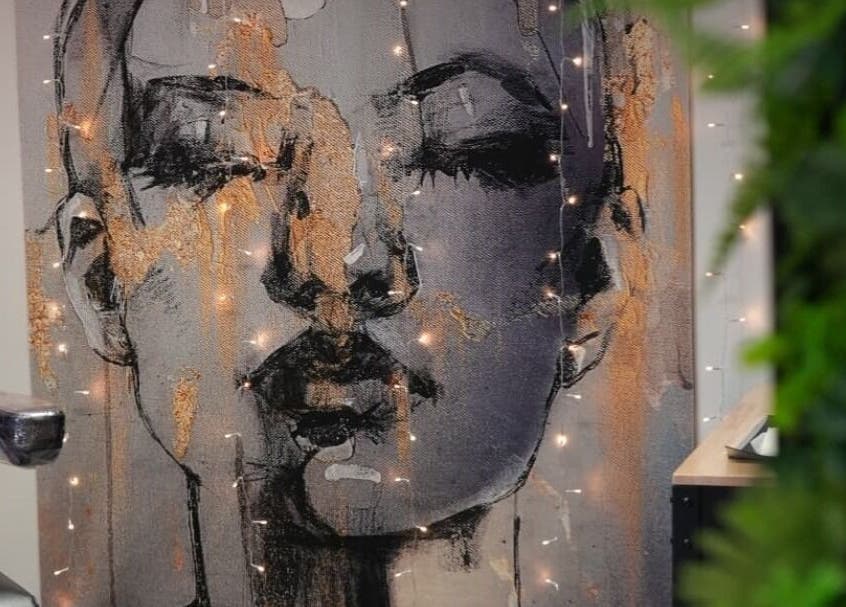 Artistic wall decor at Signature Laser, Kintore, Scotland, GB featuring a portrait with ambient lighting.