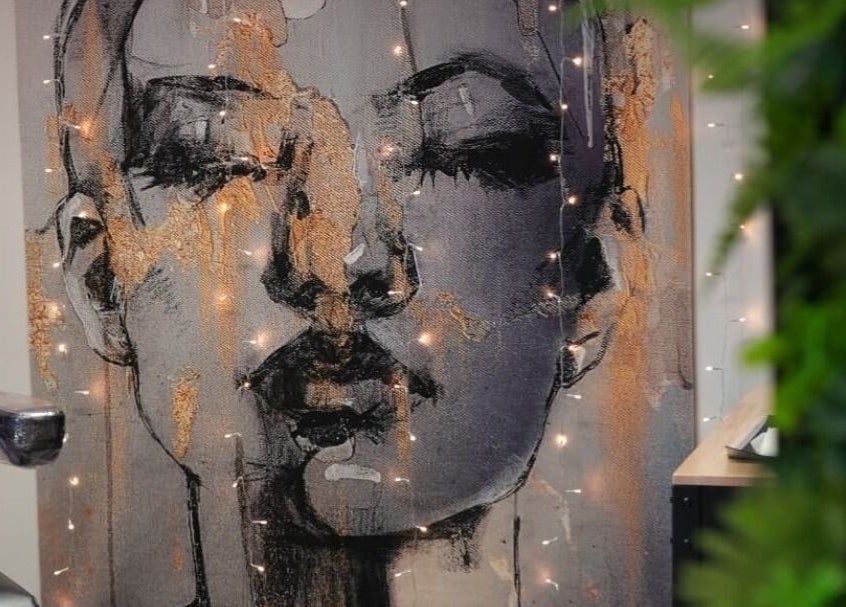 Artistic wall decor at Signature Laser, Kintore, Scotland, GB featuring a portrait with ambient lighting.