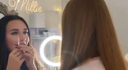 Client admires makeup in mirror at Pretty by Millie, Bewdley, England, GB, with soft lighting.