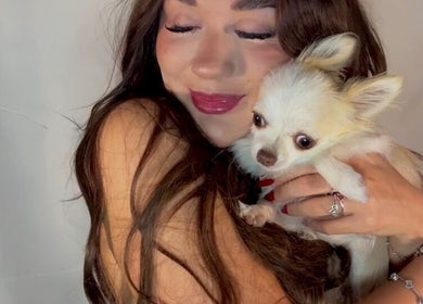 A smiling woman cuddling a small dog at Pretty by Millie, Bewdley, England, GB.