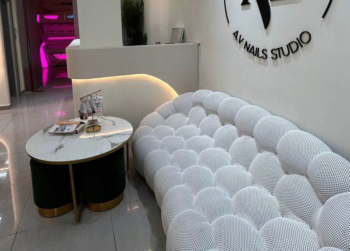 Μοντέρνος λευκός καναπές στο A.V Νails Solarium, Θεσσαλονίκη, GR, δίπλα σε στρογγυλό τραπέζι μαρμάρου.