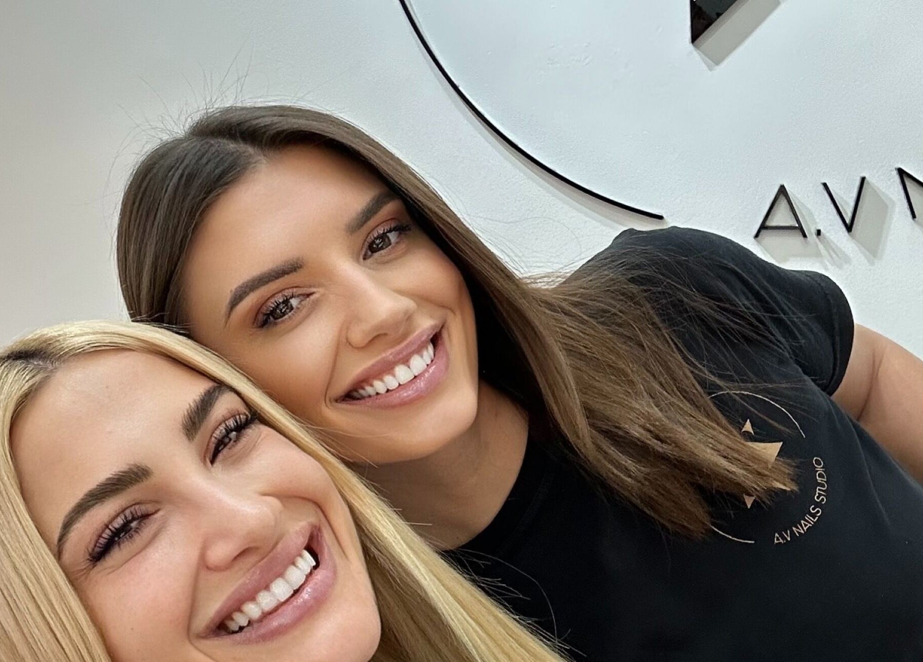 Δύο γυναίκες χαμογελούν στο A.V Νails Solarium, Θεσσαλονίκη, GR, δείχνοντας περιποίηση και χαρά.