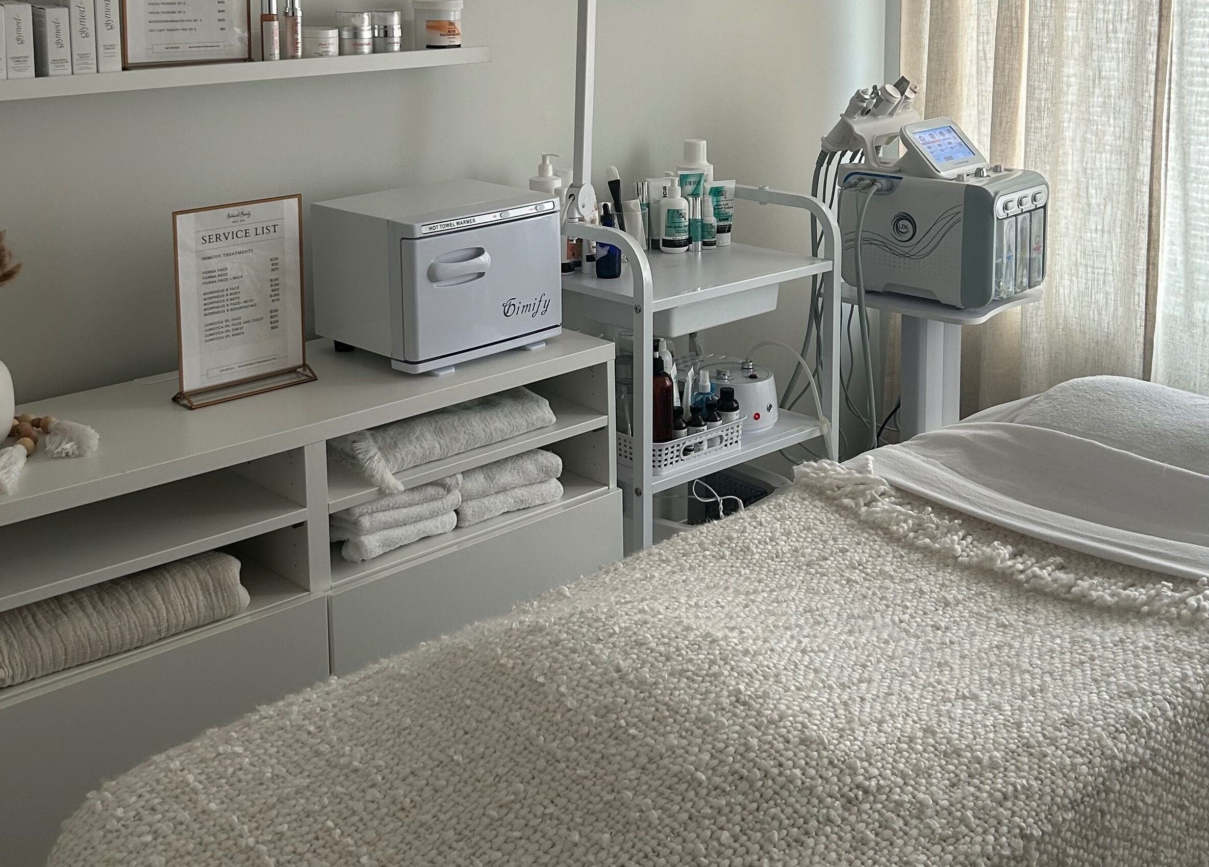 Aesthetic spa room at Balanced Beauty Med Spa, Vaughan, Ontario, CA, with plush bedding and skincare products.