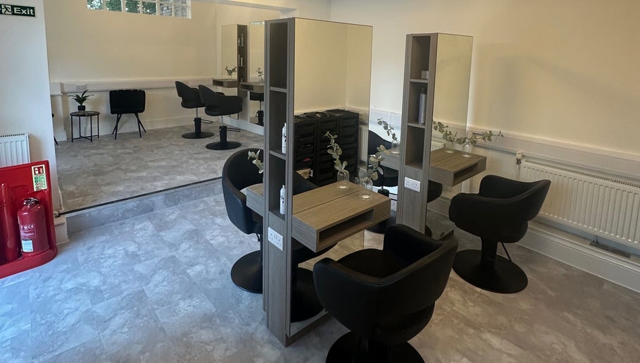 Modern salon interior at Holly Jayne Hair, Derby, England, GB, featuring elegant styling stations and chic chairs.