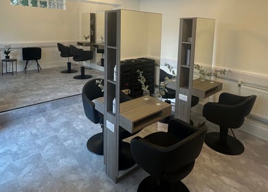 Modern salon interior at Holly Jayne Hair, Derby, England, GB, featuring elegant styling stations and chic chairs.