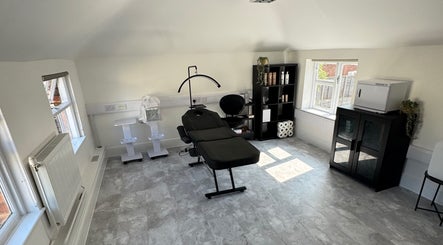 Modern treatment room at Holly Jayne Hair in Derby, England, GB, featuring a sleek black chair and storage.