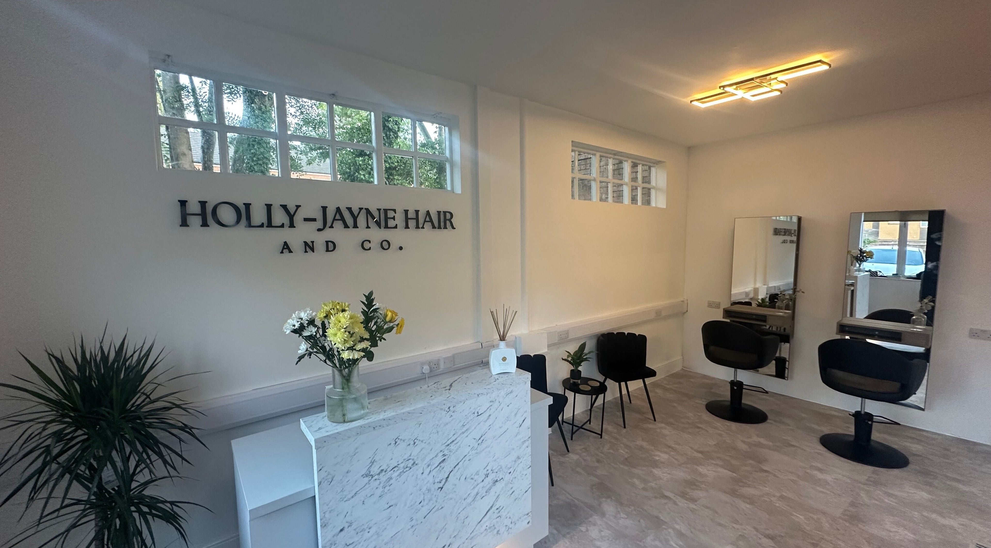 Modern salon interior at Holly Jayne Hair and Co, Derby, England, GB with stylish decor and seating.