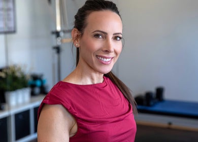 Instructor at Firefly Pilates in Potters Bar, England, GB smiling in a bright studio.