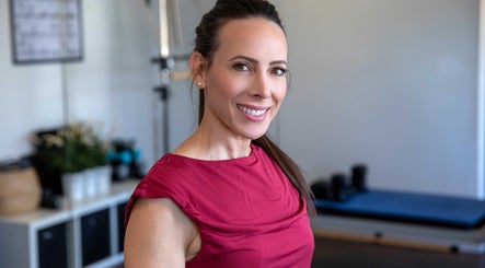 Instructor at Firefly Pilates in Potters Bar, England, GB smiling in a bright studio.