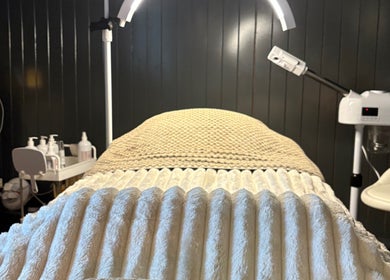 Luxurious treatment room at Sacred Roots Limited, Guernsey, Vale, GG, featuring a cozy massage table and amenities.