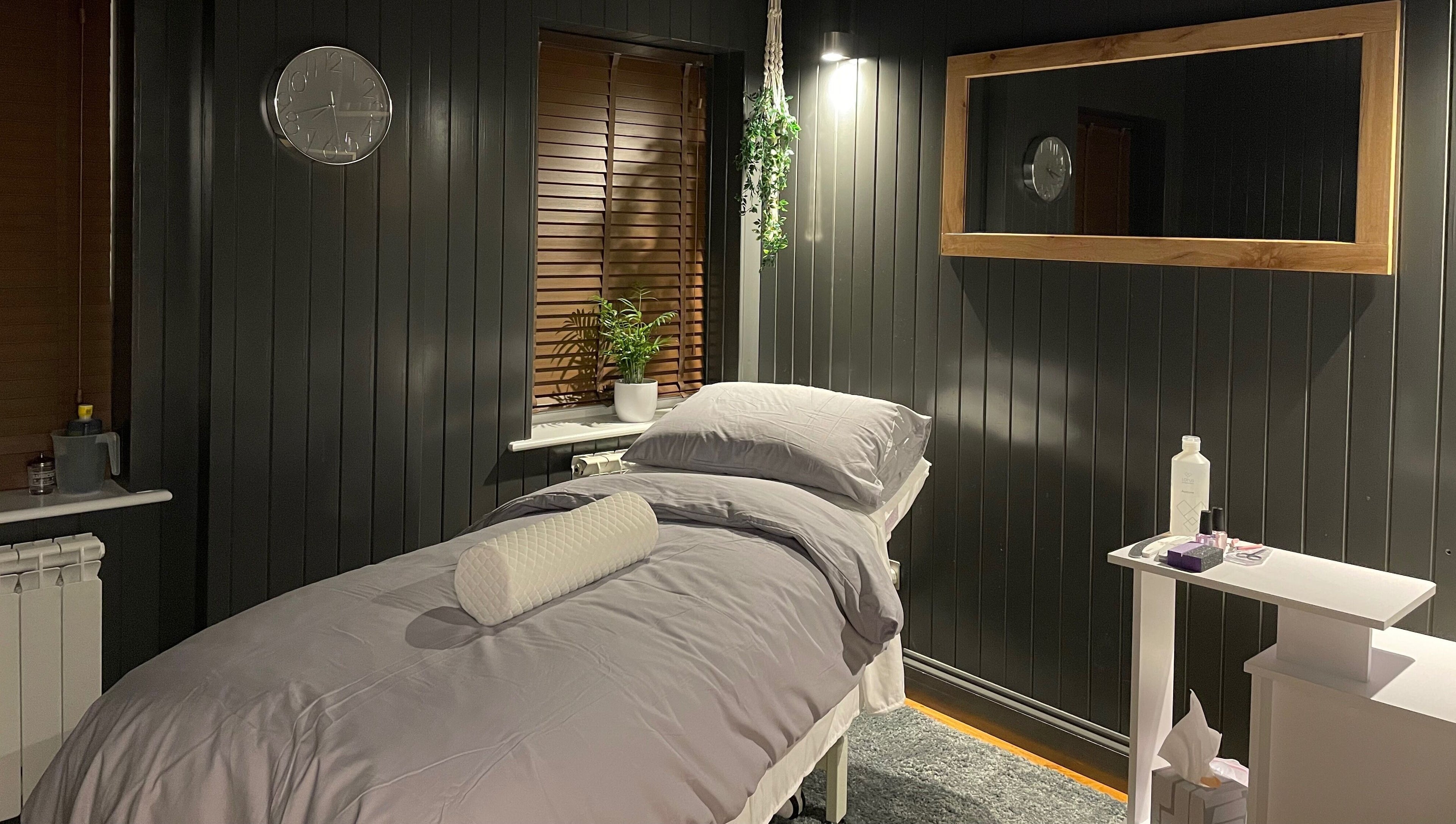 Cozy massage room at Sacred Roots Limited in Guernsey, Vale, GG, featuring a serene bed and calming decor.