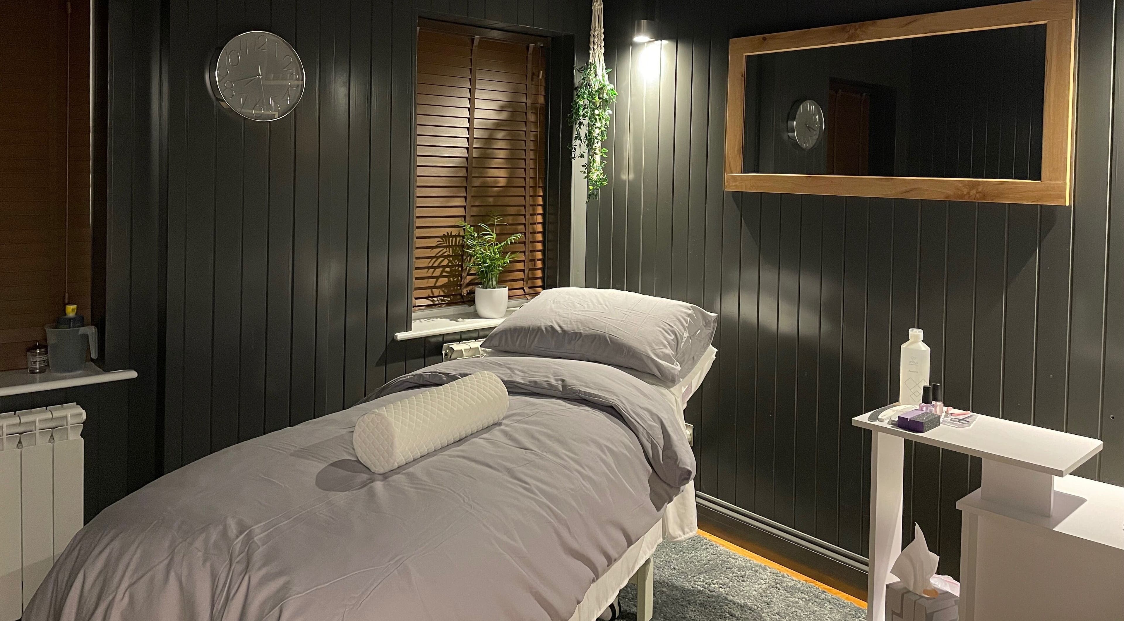 Cozy massage room at Sacred Roots Limited in Guernsey, Vale, GG, featuring a serene bed and calming decor.