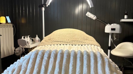 Spa treatment room at Sacred Roots Limited in Guernsey, Vale, GG with a massage table and warm lighting.