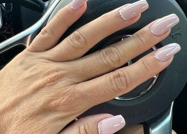 Manicured nails with pink polish from Celini Beauty Salon, Limassol, Limassol, CY on steering wheel.
