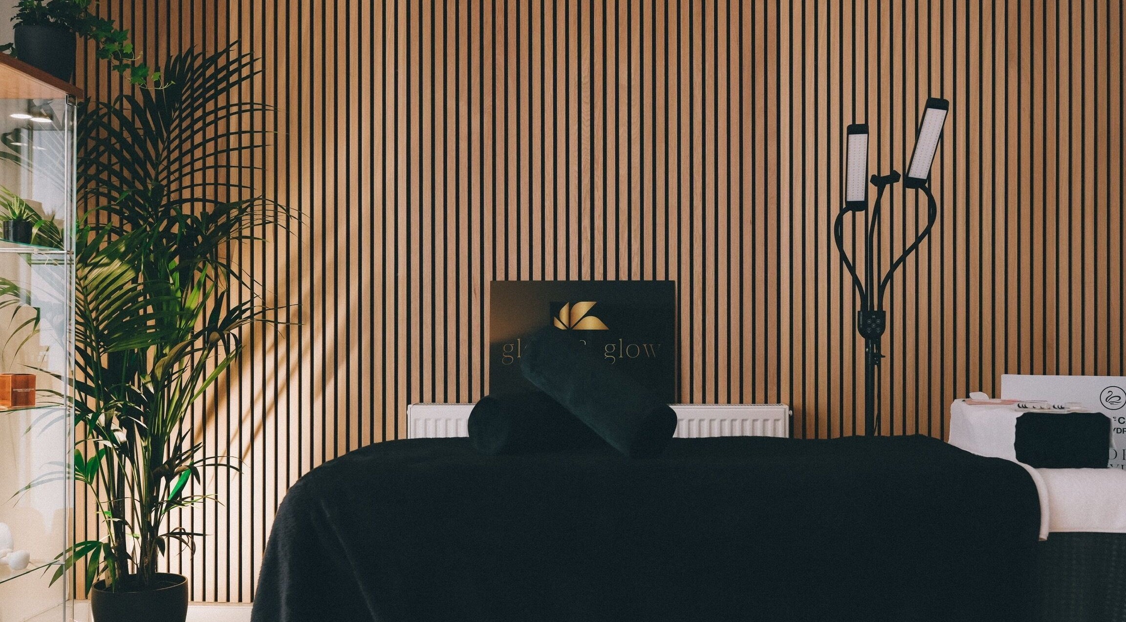 Serene treatment room at Glam and Glow Beauty Lab, Hockley Heath, England, GB. Features chic decor with plants.