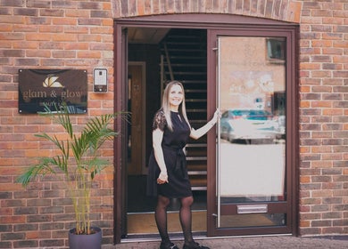 Woman welcoming at Glam and Glow Beauty Lab entrance in Hockley Heath, England, GB.