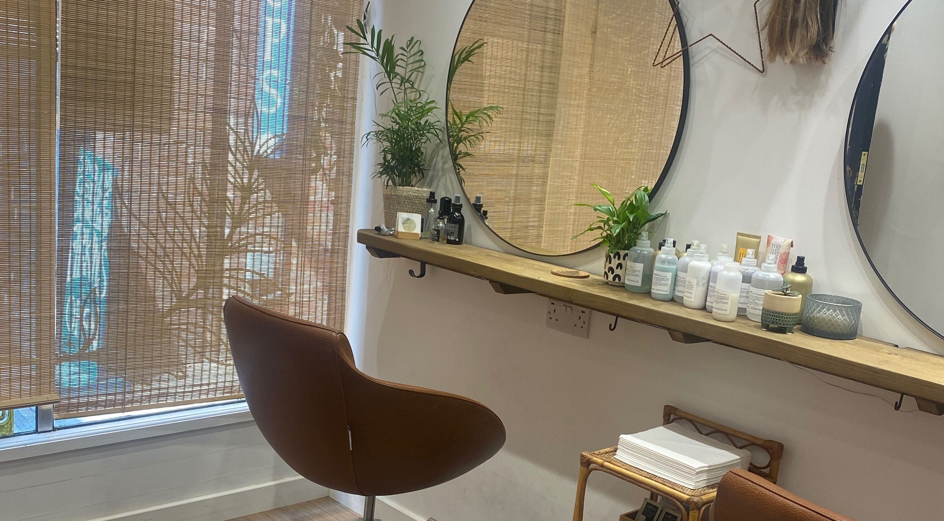 Stylish interior of Fern Hair Studio, Exeter, England, GB with elegant mirror and chic decor.