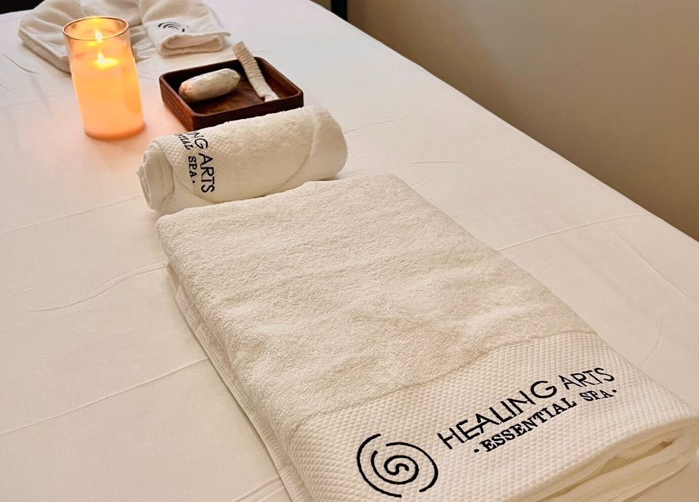 Tranquil spa setup at Healing Arts Essential Spa in Melbourne, Victoria, AU with candle and towels.