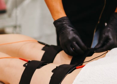 Lymphatic drainage treatment at V Fritz Lymphatic Drainage Specialist in London, GB with black-gloved hands.