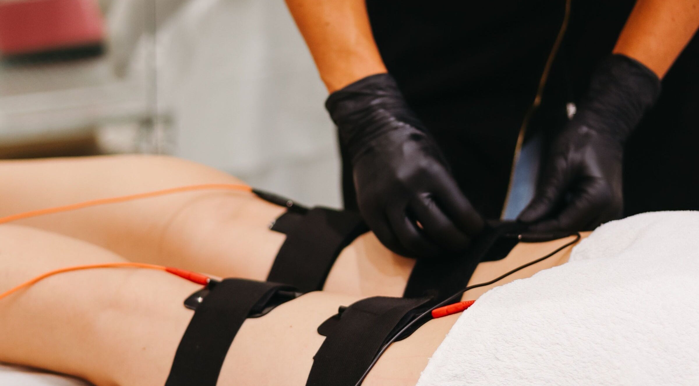 Lymphatic drainage treatment at V Fritz Lymphatic Drainage Specialist in London, GB with black-gloved hands.