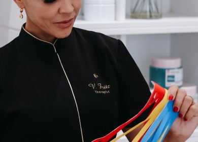 V Fritz Lymphatic Drainage Specialist in London, GB holding colorful therapy strips for patient care.