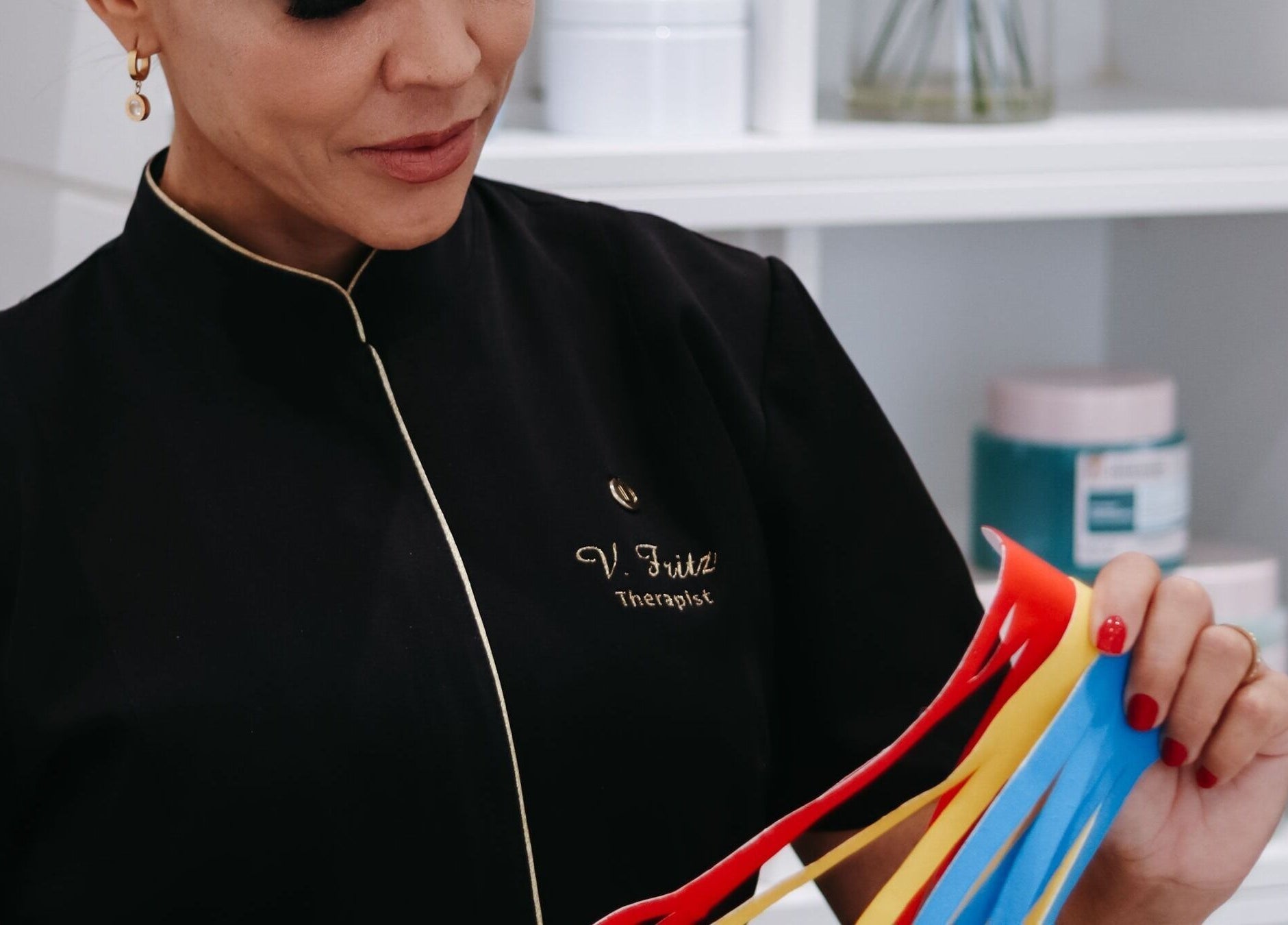 V Fritz Lymphatic Drainage Specialist in London, GB holding colorful therapy strips for patient care.