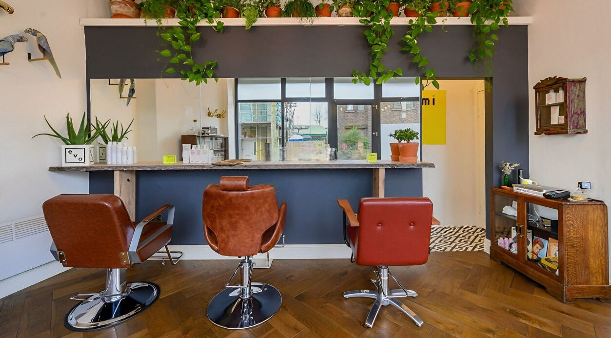 Stylish interior of Eduardo aka XU at Romi Salon in London, England, GB with elegant chairs and plants.