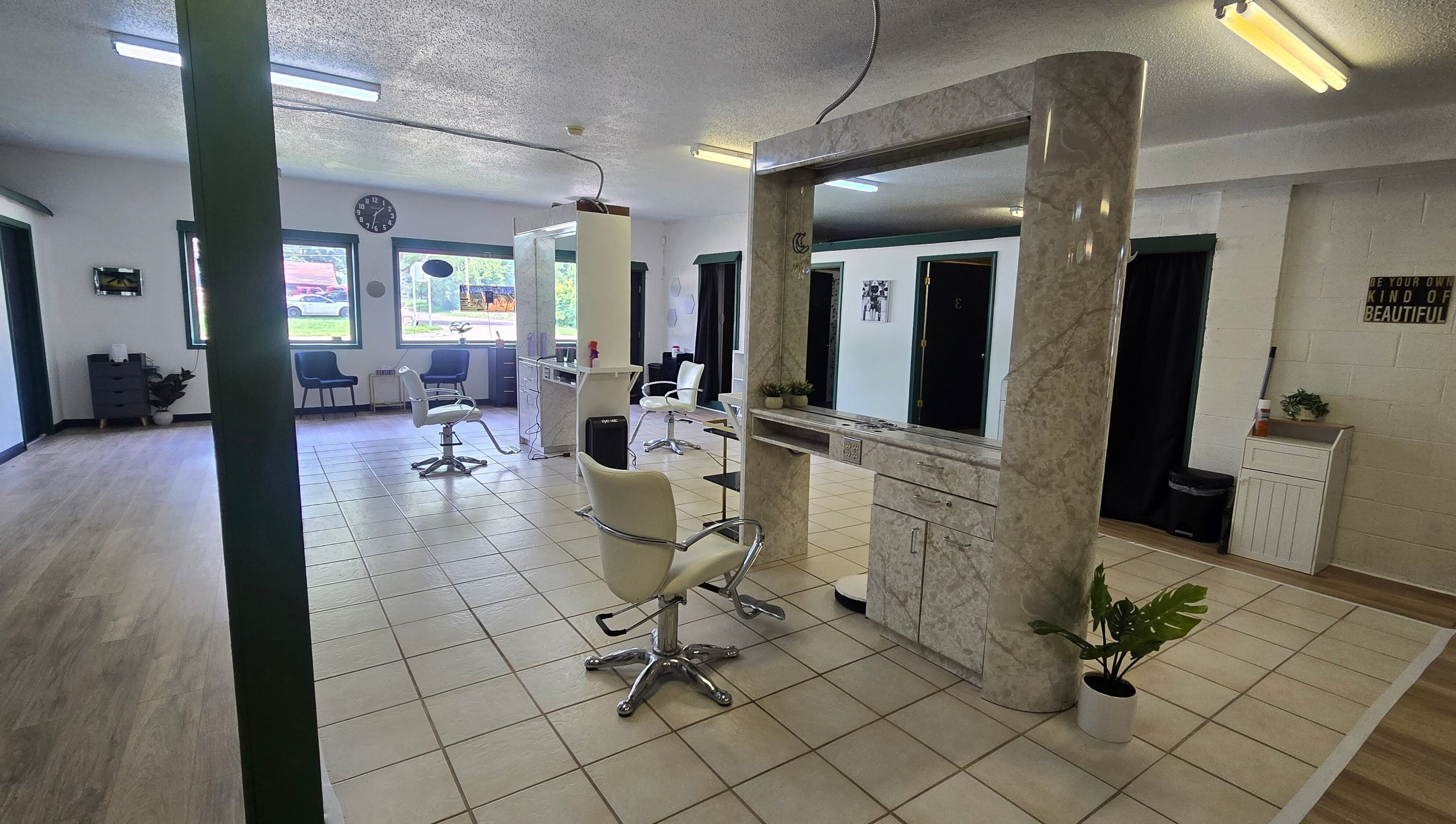 Modern salon interior at Skin Deep Studio, Remus, Michigan, US with stylish chairs and large mirrors.