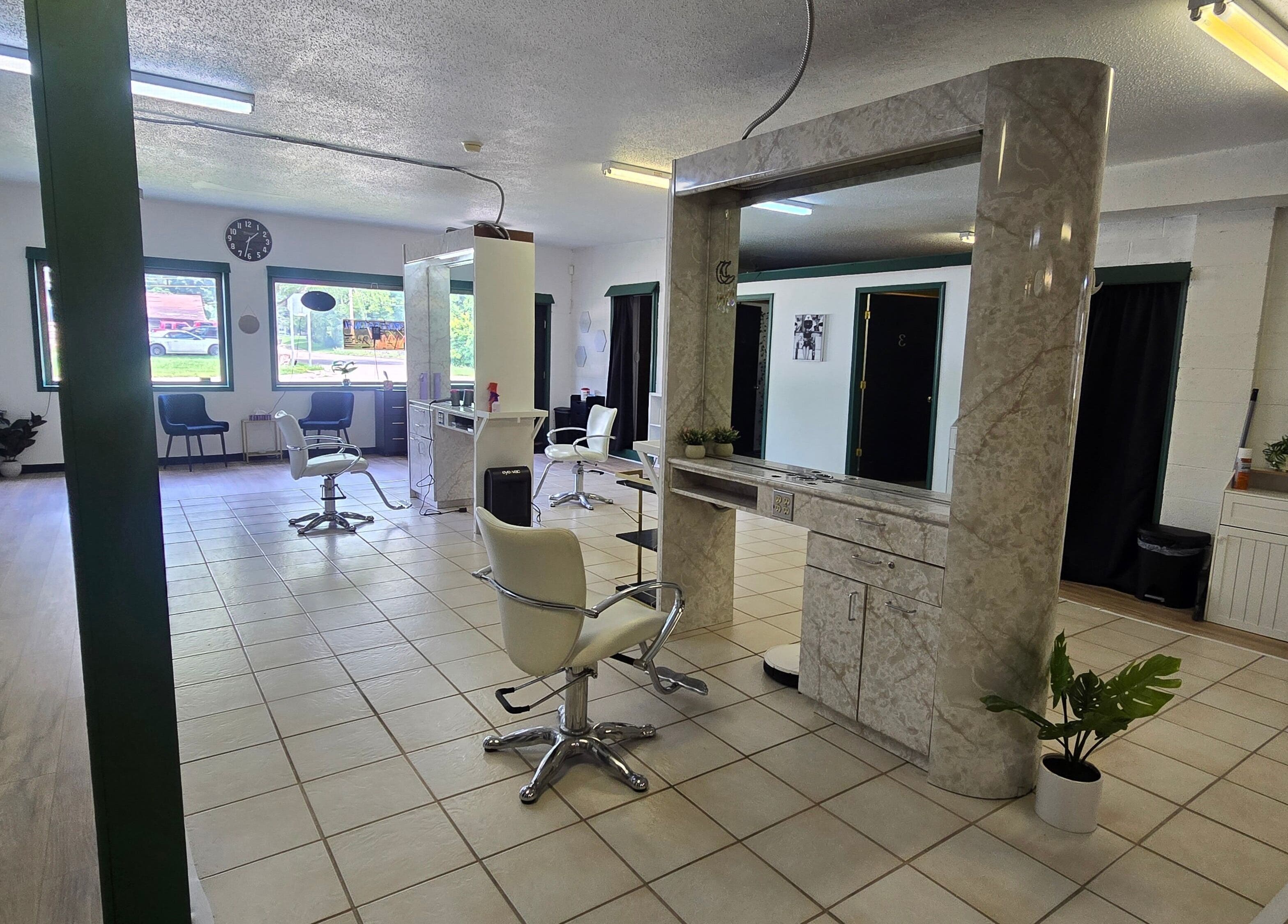 Modern salon interior at Skin Deep Studio, Remus, Michigan, US with stylish chairs and large mirrors.