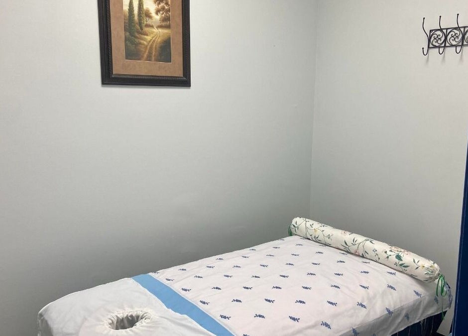 Massage room at Revive Asian Massage, Overland Park, Kansas, US with a serene treatment bed and artwork.