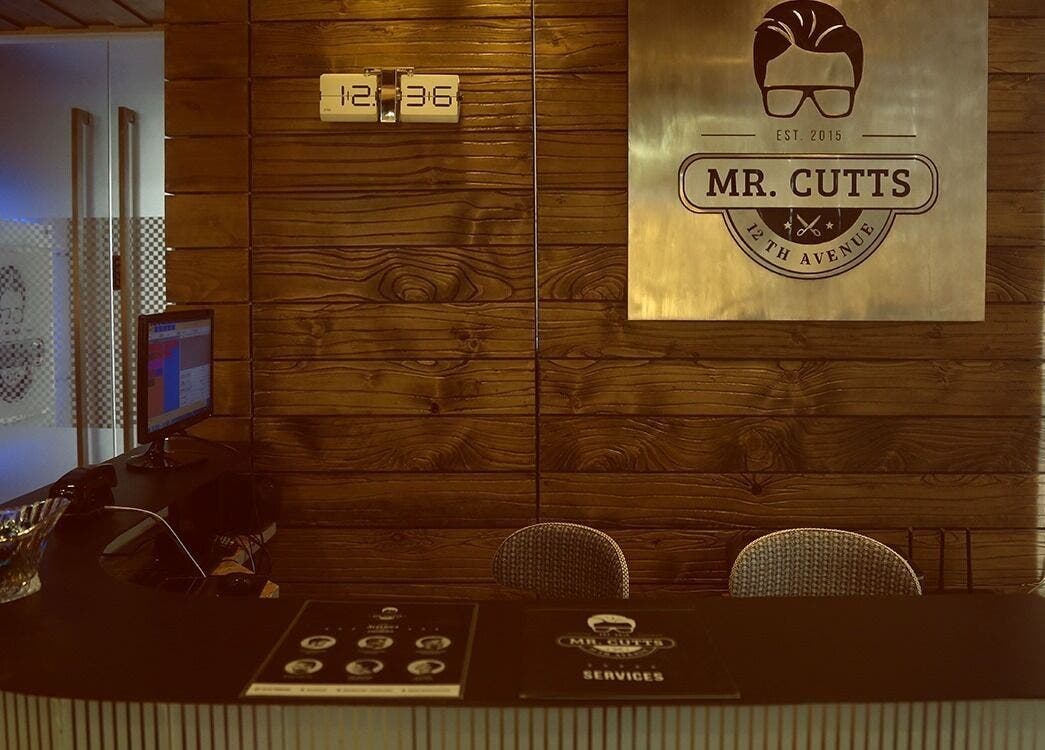 Reception area of Mr Cutts, Dhaka, Dhaka Division, BD with wooden decor and branding sign.