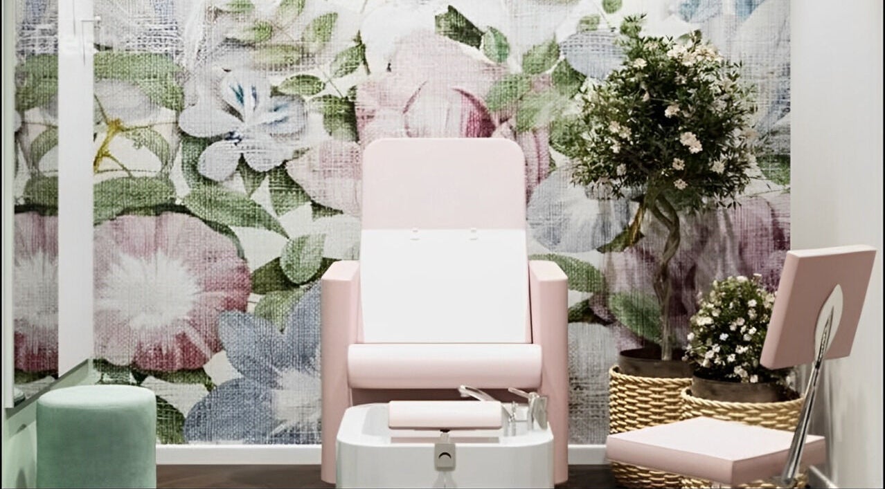 Interno elegante di Alchimie SAGL a Mendrisio, Ticino, CH con sedia rosa e parete floreale.