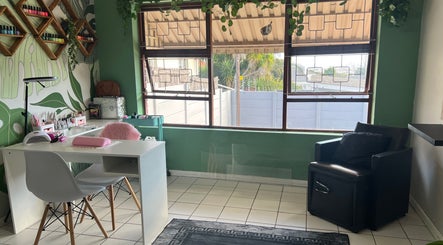 Bright interior of The A List Beauty Salon in Gqeberha, Eastern Cape, ZA featuring stylish workspace and greenery.