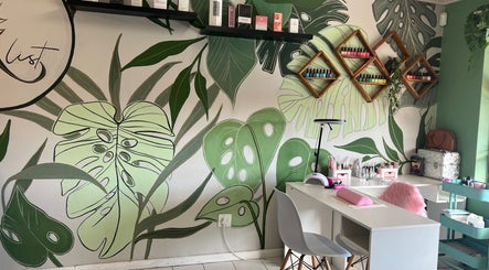 The A List Beauty Salon in Gqeberha, Eastern Cape, ZA features lush tropical decor with nail polish displays.