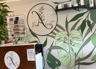 The A List Beauty Salon reception area with lush green decor in Gqeberha, Eastern Cape, ZA.