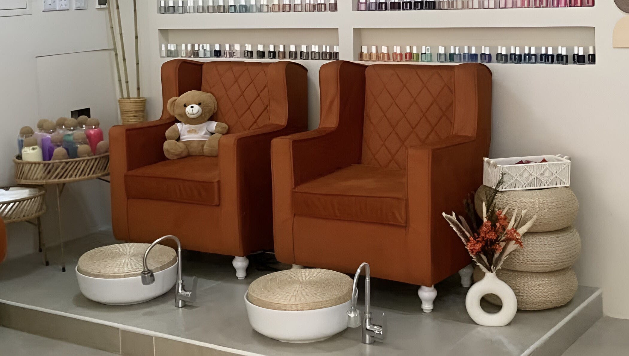 Warm pedicure chairs at Luxurious Lash Salon Muweilah, Sharjah, AE with nail polish display and teddy bear.