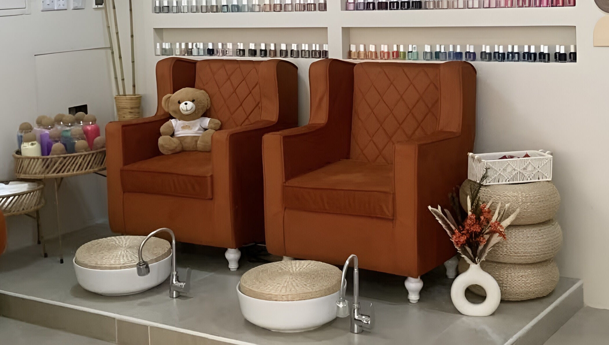 Warm pedicure chairs at Luxurious Lash Salon Muweilah, Sharjah, AE with nail polish display and teddy bear.