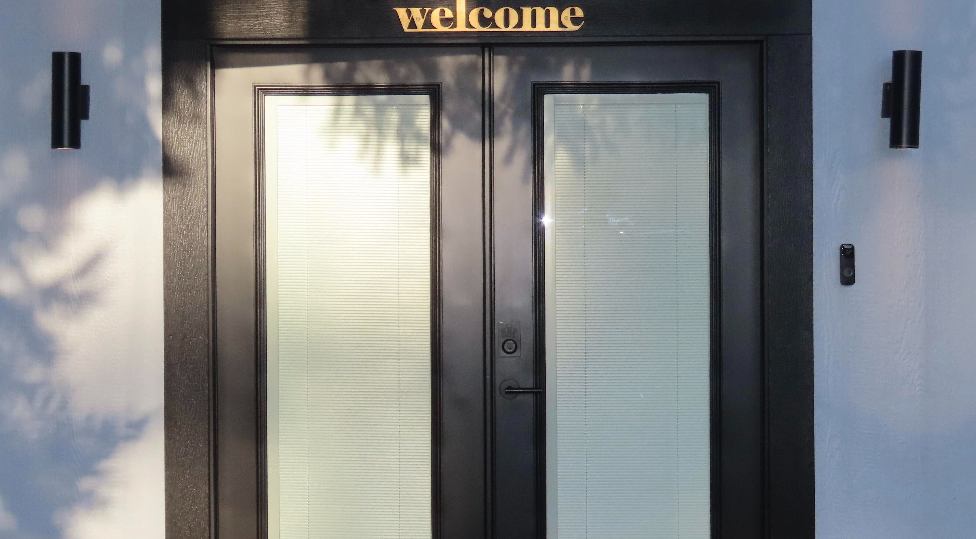 Front entrance of Belas Esthetics, Tacoma, Washington, US, with 'welcome' sign and elegant door design.