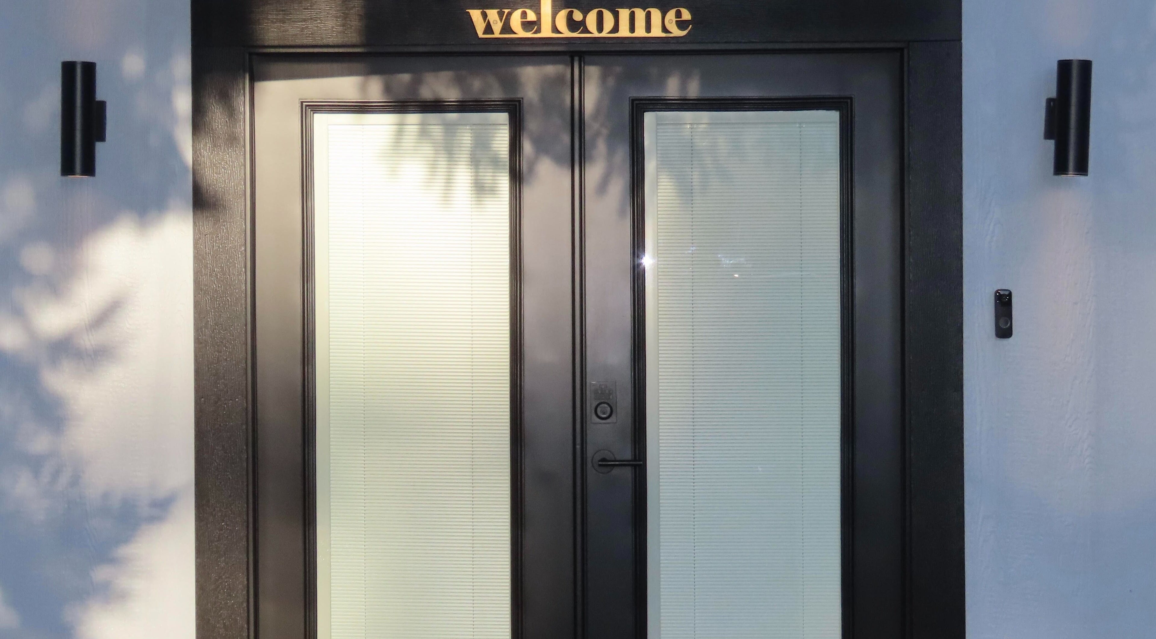 Front entrance of Belas Esthetics, Tacoma, Washington, US, with 'welcome' sign and elegant door design.