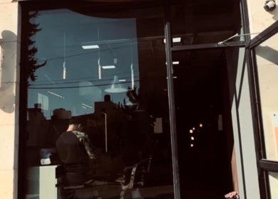 واجهة DH Barber Shop في عمان، محافظة عمان، JO مع لافتة الحلاقة التقليدية.