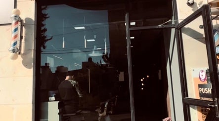 واجهة DH Barber Shop في عمان، محافظة عمان، JO مع لافتة الحلاقة التقليدية.