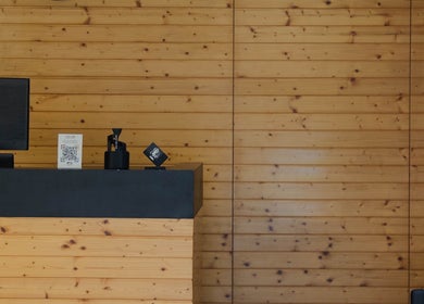 Recepção acolhedora do LiMBO Men’s Salon, Merelim S. Pedro, Braga, PT com parede de madeira.