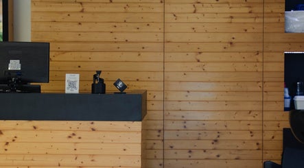 Recepção acolhedora do LiMBO Men’s Salon, Merelim S. Pedro, Braga, PT com parede de madeira.
