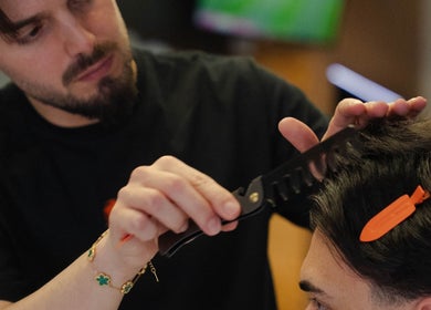 Barbeiro em ação no LiMBO Men’s Salon, Merelim S. Pedro, Braga, PT, cuidando do cabelo de um cliente.