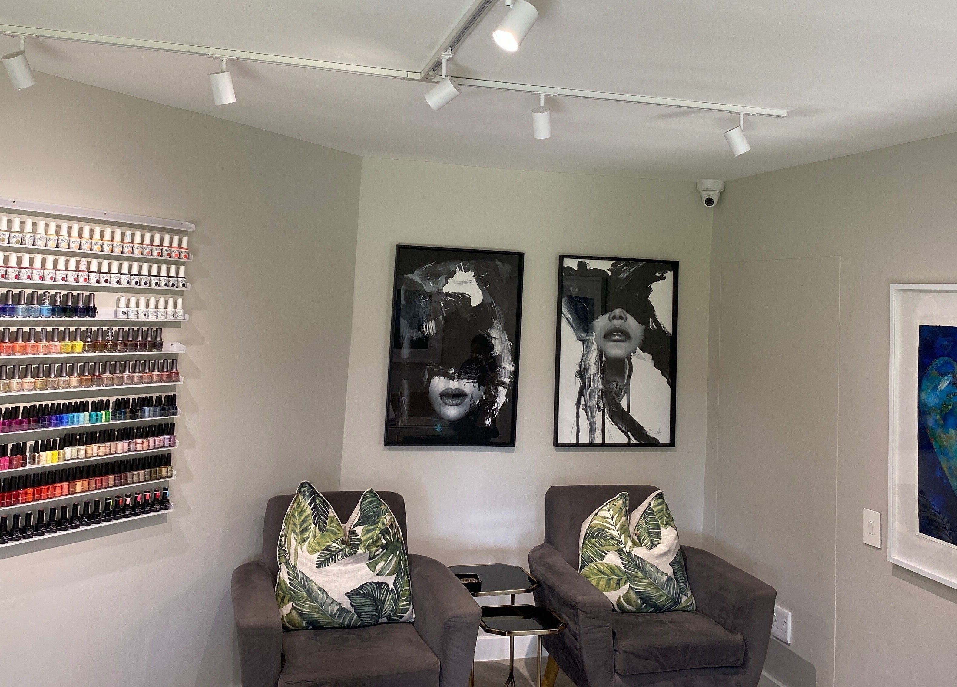 Nail polish display and cozy seating at DASH, Johannesburg, Gauteng, ZA. Elegant salon decor with vibrant colors.