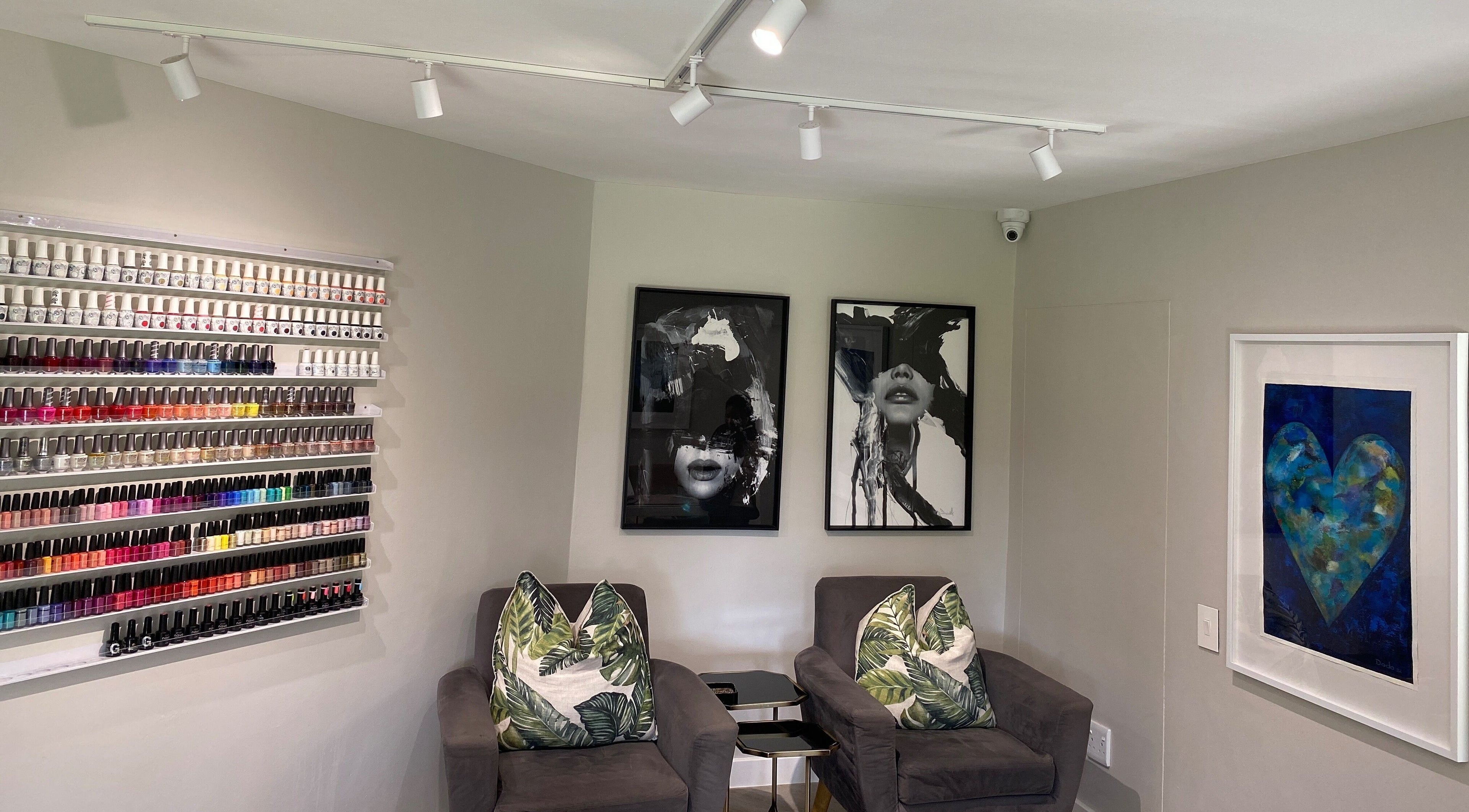Nail polish display and cozy seating at DASH, Johannesburg, Gauteng, ZA. Elegant salon decor with vibrant colors.