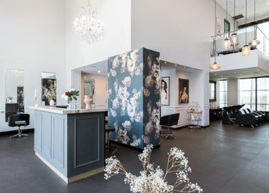 Chic salon interior at Vescada Hair and Beauty, Bella Vista, New South Wales, AU with floral walls and modern seating.