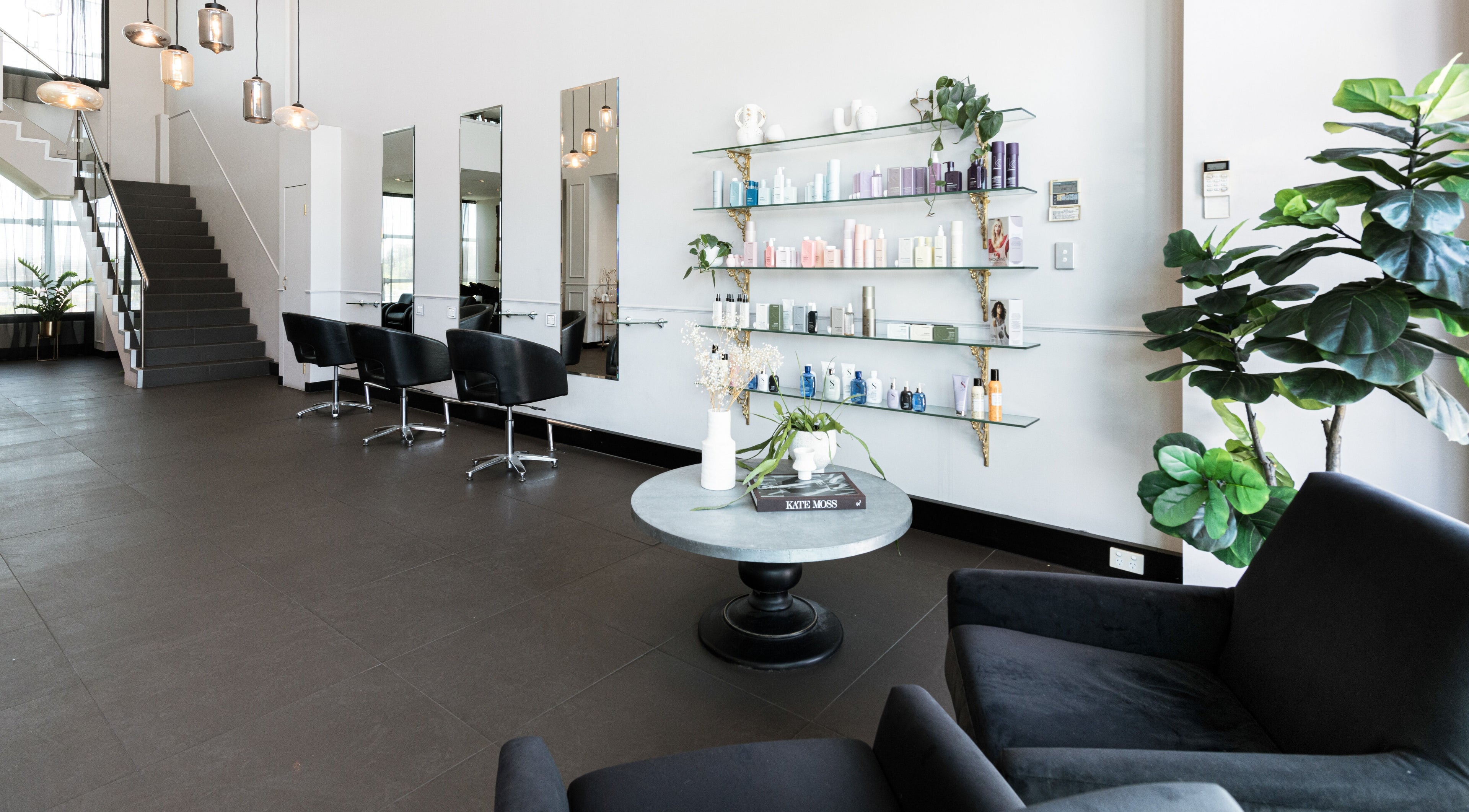 Chic interior of Vescada Hair and Beauty, Bella Vista, New South Wales, AU, showcasing styling chairs and product shelves.